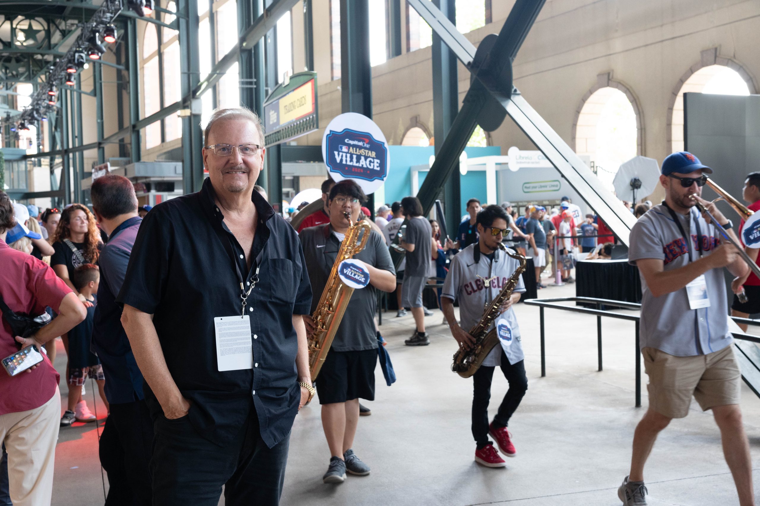 Fazzino at the MLB All-Star Game venue with a band walking behind him playing horned instruments