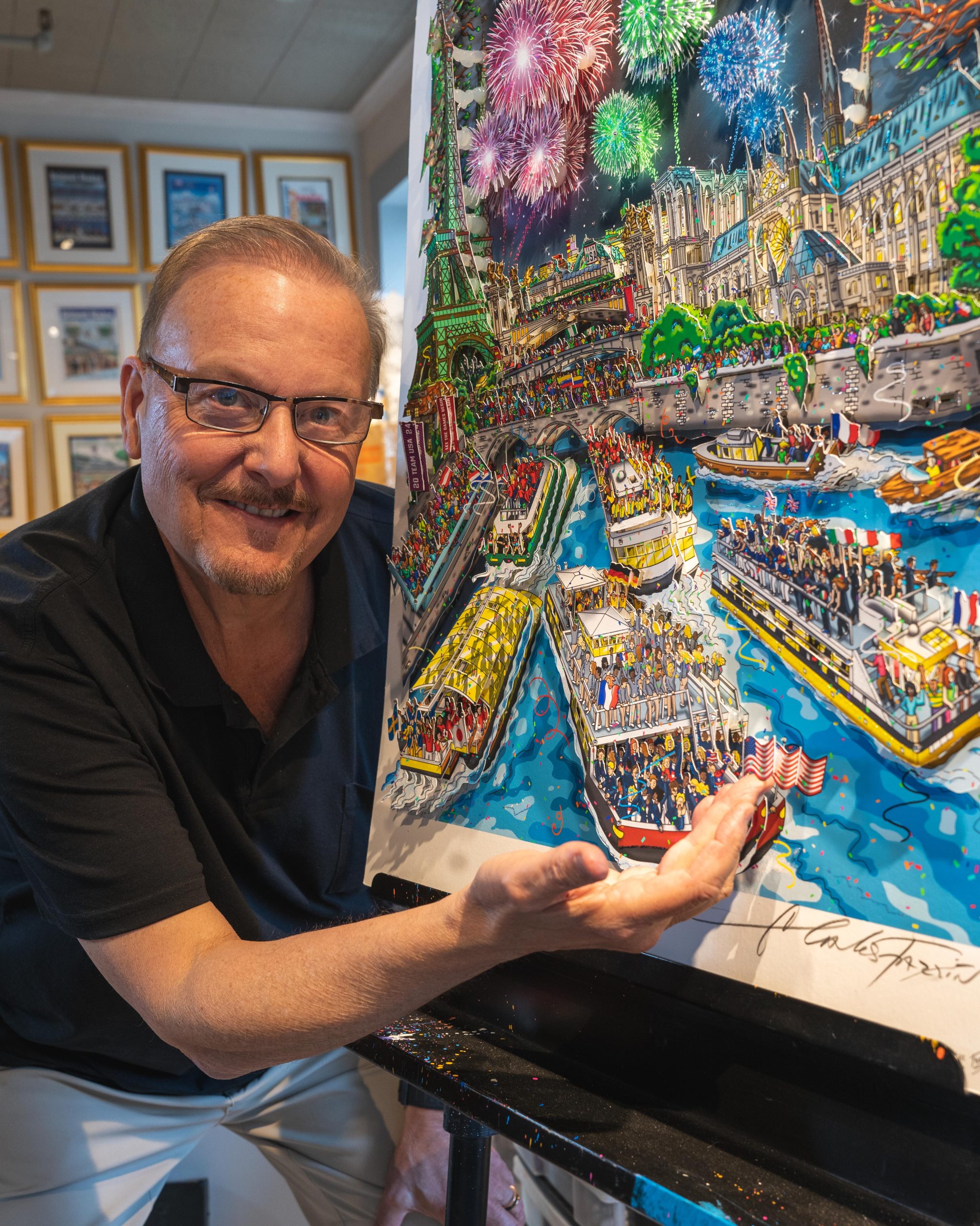 Fazzino stands in front of his artwork for the 2024 Paris Olympics, his hand underneath one of the 3D boats floating in the Seine River