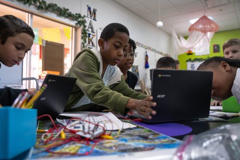 A group of STEM students are immersed connecting touchpads to Fazzino's artwork to create sounds bites about the objects