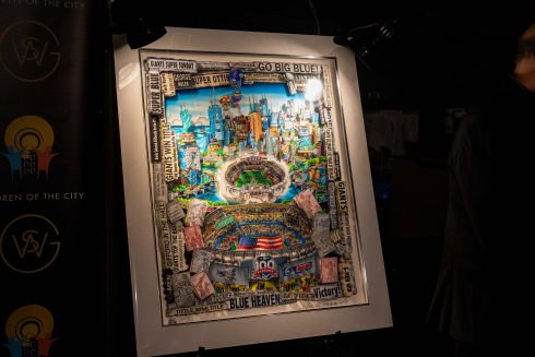 A framed version of the Celebrating 100 Years of the NY Giants artwork sits on an easel 