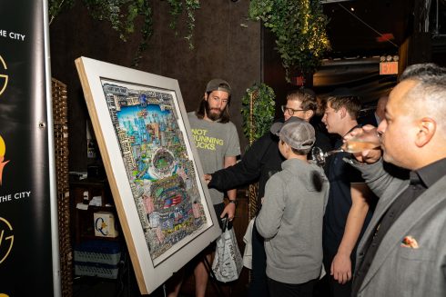 The auction winners and other attendees take a close-up look at Fazzino's commemorative artwork which is full of Giants history